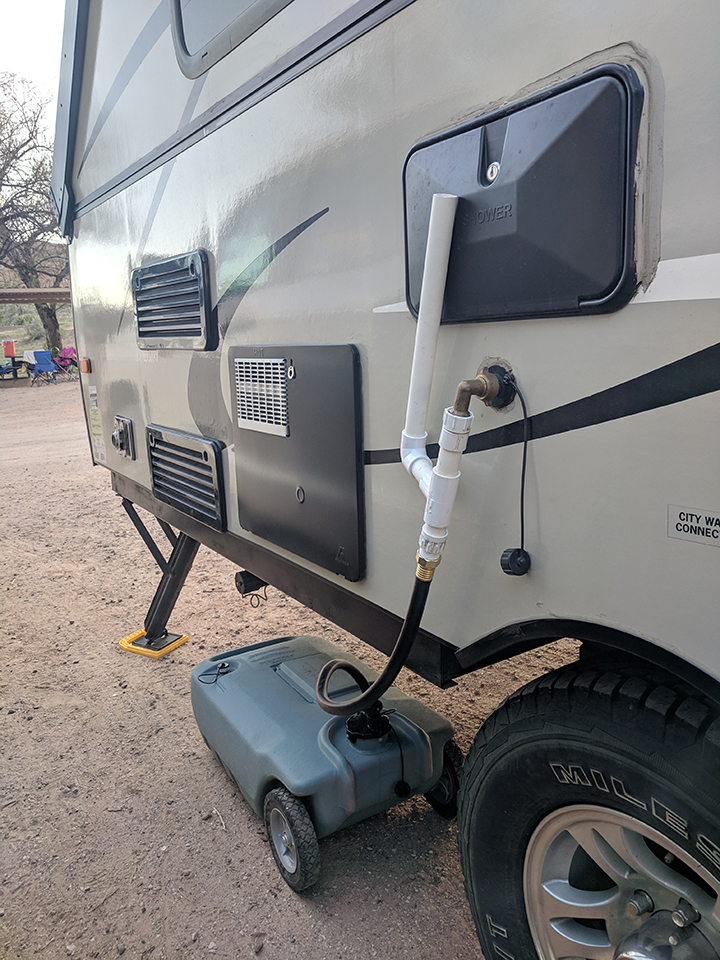 Grey water tank connected to PVC connections on a-frame camper